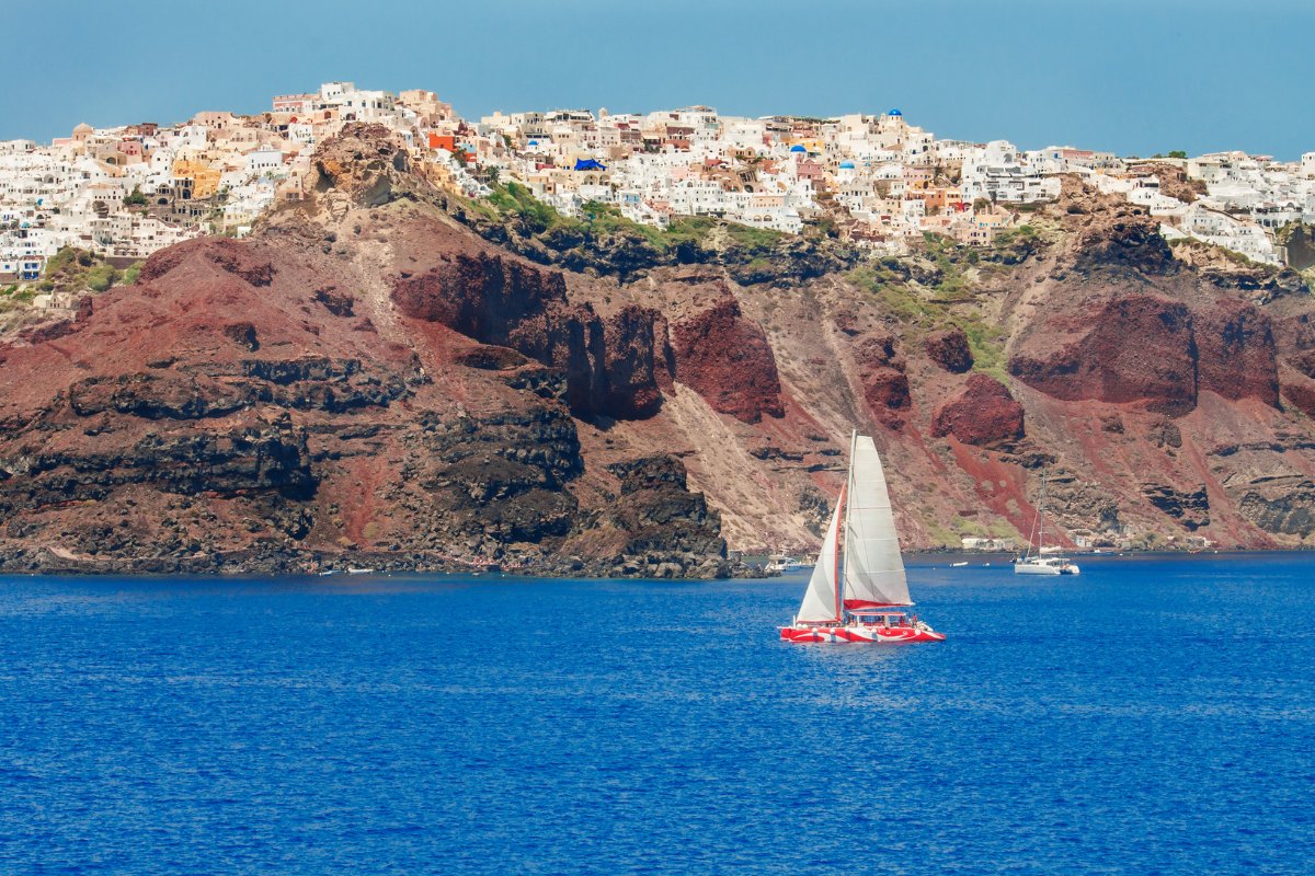 Oijos saulėlydis Santorinyje, burlaivis įlankoje, Kikladai